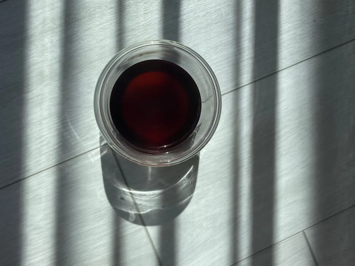 Black coffee in a glass among window shadows