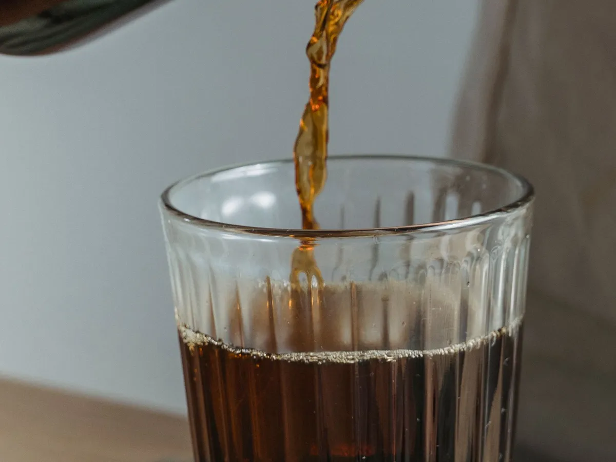 Brewed coffee being poured into a glass
