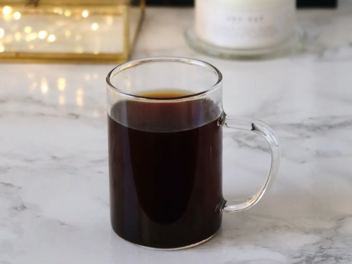 Black coffee in a glass mug on a light countertop