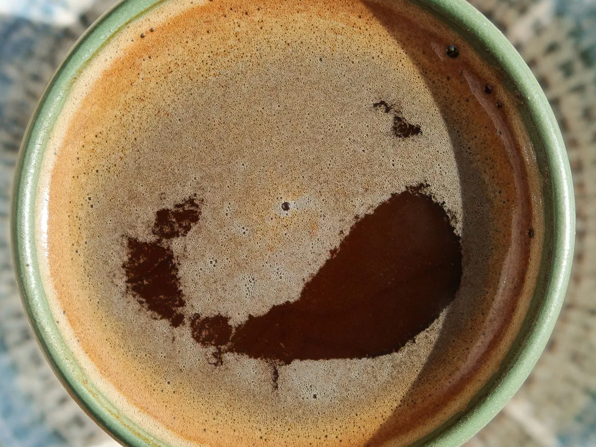 绿色杯子中带油脂的浓缩咖啡俯视图