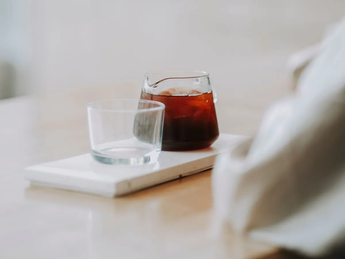 玻璃杯旁玻璃壶中的冲泡咖啡